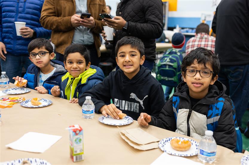 Trinity Elementary students eat donuts with dudes